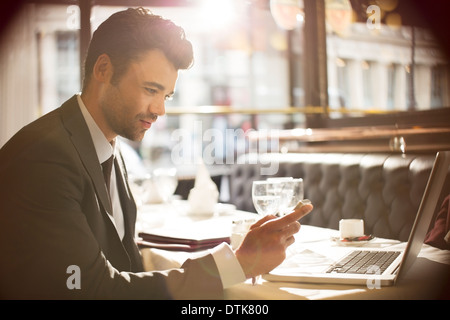 Uomo d affari con computer portatile in ristorante Foto Stock