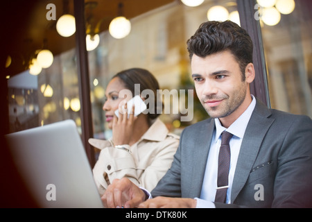 La gente di affari lavora al cafè sul marciapiede Foto Stock