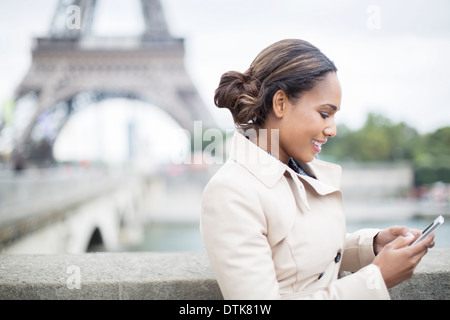 Imprenditrice tramite telefono cellulare vicino alla Torre Eiffel, Parigi, Francia Foto Stock