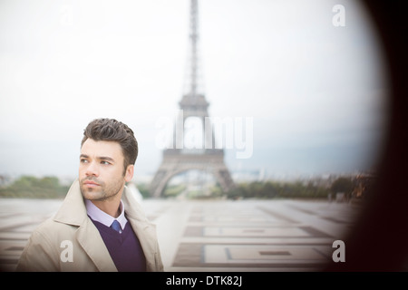 Imprenditore in piedi vicino alla Torre Eiffel, Parigi, Francia Foto Stock