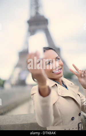 Donna di scattare una foto davanti alla Torre Eiffel, Parigi, Francia Foto Stock