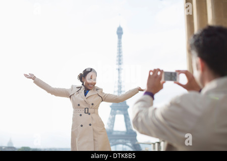 L'uomo fotografare la ragazza di fronte alla Torre Eiffel, Parigi, Francia Foto Stock