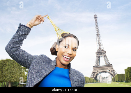 La donna posa con souvenir di fronte alla Torre Eiffel, Parigi, Francia Foto Stock