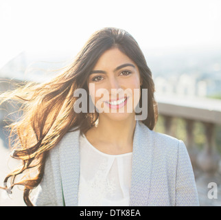 Vento capelli lunghi di donna sorridente all'aperto Foto Stock