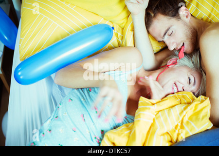 Giovane giocando a letto con palloncini Foto Stock