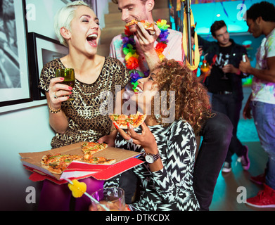 Gli amici di mangiare la pizza a parte Foto Stock