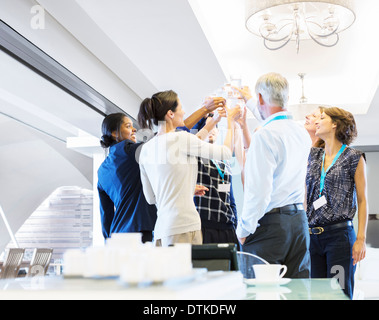 La gente di affari di tostatura bicchieri di acqua Foto Stock