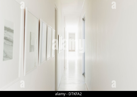 Fotografie incorniciate appesi sulle bianche pareti del corridoio Foto Stock