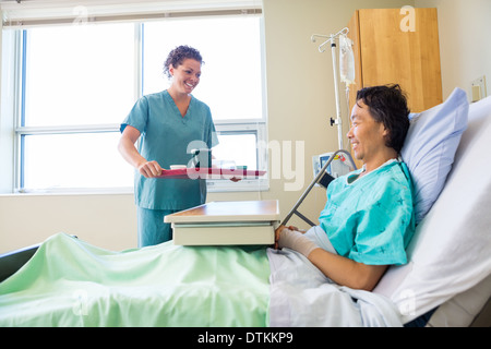 Infermiere portando la colazione per il paziente in ospedale Foto Stock