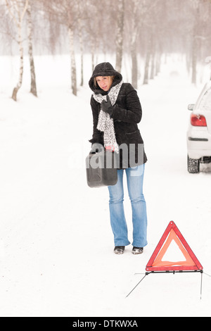 Donna che cammina con il gas può auto neve Foto Stock