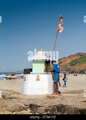 India, Goa, Vagator beach, fisherman rendendo offrendo al santuario indù Foto Stock