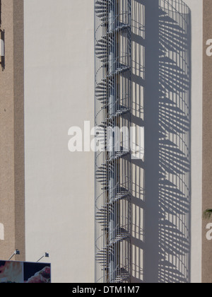 Uscita di emergenza scalinata a spirale e la sua ombra riflessa su un edificio di Playa Las Americas Tenerife Isole Canarie Spagna Foto Stock