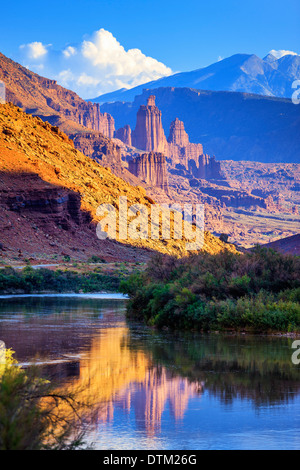 Le Torri di Fisher parzialmente illuminata dal sole del tardo pomeriggio si riflette nel fiume Colorado vicino a Moab,Utah Foto Stock