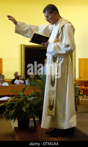 Vestita di un sacerdote cattolico gesti durante la lettura di un sermone in una chiesa a Irvine, CA. Foto Stock