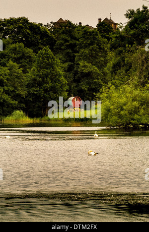 Stile tradizionale Gypsy Caravan annidato in alberi a lato del lago Foto Stock