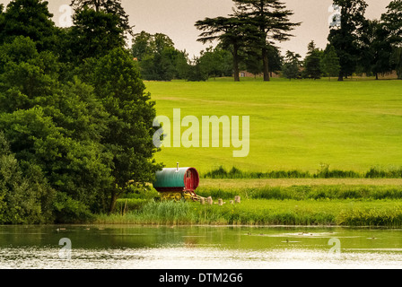 Stile tradizionale Gypsy Caravan annidato in alberi a lato del lago Foto Stock