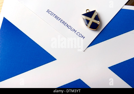 Scozia indipendenza immagine generica di una piccola Scottish si intraversa fob di smalto su una bandiera scozzese e Scotlands futuro documento Foto Stock