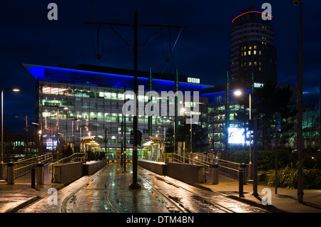 Il MediaCityUK Metrolink alla fermata del tram e BBC studio edifici di notte, Salford Quays, Manchester, Inghilterra, Regno Unito. Foto Stock