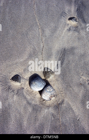 Ciottoli e modelli di sabbia su una spiaggia in Sud Uist, Ebridi Esterne, Scotland, Regno Unito. Foto Stock