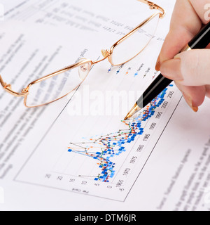 Imprenditrice la mano che mostra lo schema sulla relazione finanziaria con la penna. Foto Stock