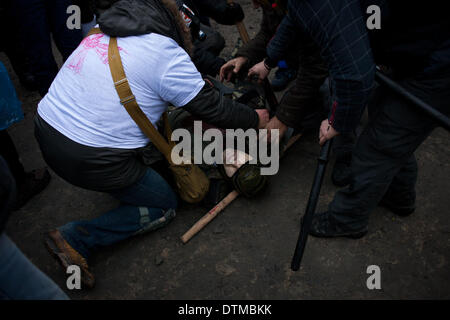 Kiev, Ucraina. Xx Febbraio 2014. I manifestanti portano un ferito i compagni di protester in Kiev. Centinaia di contestatori armati carica barricate della polizia giovedì di kiev central Piazza Indipendenza, nonostante una tregua chiamato poche ore prima dal paese del presidente merlata. Manifestanti hanno spinto la polizia indietro per circa 200 metri e sono state in controllo della maggior parte della piazza che avevano occupato all'inizio dell'Ucraina di tre-mese-vecchio crisi politica Credito: ZUMA Press, Inc./Alamy Live News Foto Stock