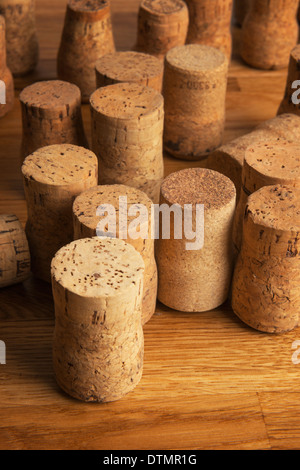 Una collezione di tappi di champagne su un piano di lavoro in legno di quercia Foto Stock