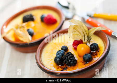 Dolce creme brulee dessert guarnita con frutti di bosco freschi Foto Stock