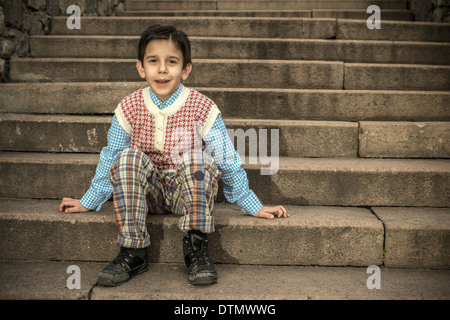 Bambino seduto sulle scale. Immagine vintage Foto Stock