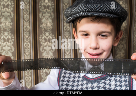 Bambino considerato analogico pellicola fotografica. Abbigliamento vintage e lo sfondo Foto Stock