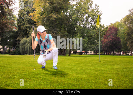 Femmina giocatore di golf con un club di golf sul corso Foto Stock