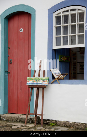 Il Brasile, Parati (Paraty). Storica città coloniale, l'UNESCO. Colorati tipici di porte e finestre, piccolo dipinto sul cavalletto. Foto Stock