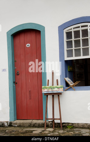 Il Brasile, Parati (Paraty). Storica città coloniale, l'UNESCO. Colorati tipici di porte e finestre, piccolo dipinto sul cavalletto. Foto Stock