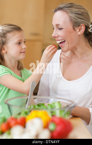 Alimentazione ragazza sua madre con insalata Foto Stock