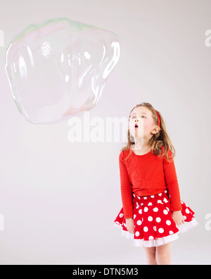 Poco carino ragazza rendendo le bolle di sapone Foto Stock