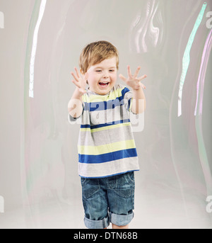 Poco carino ragazzo giocando a bolle di sapone Foto Stock