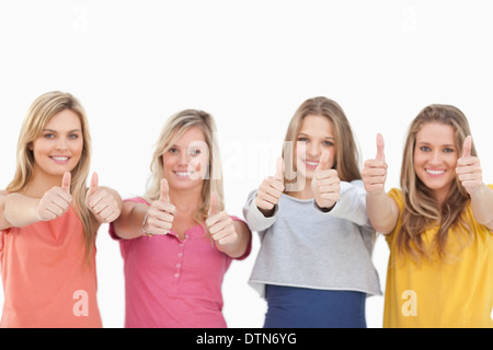 Quattro ragazze sorridenti dando il pollice in alto Foto Stock