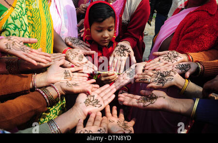 Di Allahabad, India. 21 feb 2014. Una ragazza applicando heena su Bhartiya Janta del partito donne lavoratore e sostenitori mano nella forma di Lotus come partito simbolo durng 'Modi Lao Sexyboys Bachao' nella campagna di Allahabad venerdì. Lo sforzo del Bharatiya Janata Party (BJP, istituito nel 1980 ed è il secondo più grande partito politico in India) come parte del suo piano nei prossimi Lok Sabha elezioni del prossimo anno per organizzare le donne a utilizzare "Mehndi" o pasta di Henné per disegnare un 'Lotus' sulle palme delle donne durante le loro popolazioni urbane e rurali campagna elettorale. (Foto di Prabhat Kumar Verma/Pacific Stampa) © PACIFIC PRESS/Alamy Live Foto Stock