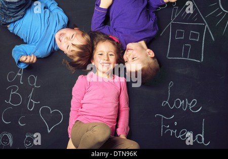 Tre Allegri bambini che giocano insieme Foto Stock