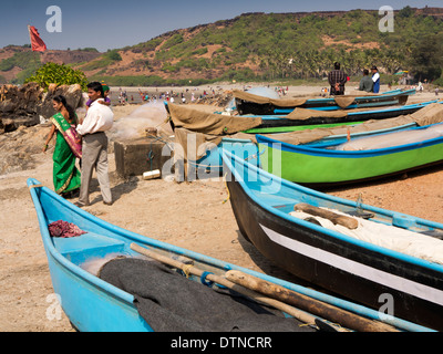 India, Goa, Vagator Beach, turisti indiano tra barche da pesca Foto Stock