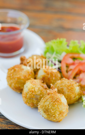 Fritte crocchette di patate servita con salsa di pomodoro e verdure fresche Foto Stock