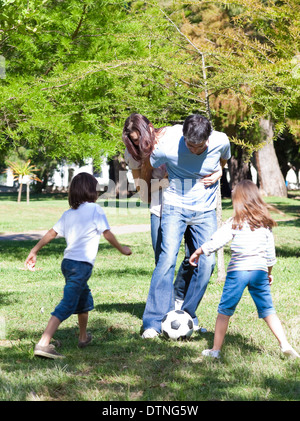 Famiglia vivace che giocano a calcio Foto Stock