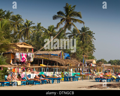 India, Goa, Morjim, Vithaldaswada beach, i turisti a prendere il sole sulle sedie a sdraio Foto Stock