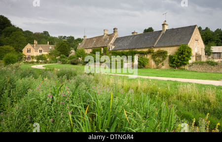 Pittoreschi casolari accanto al fiume occhio in Cotswolds villaggio di Upper Slaughter, Gloucestershire, Inghilterra. Foto Stock