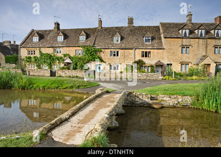 Cottages e passerella sul fiume occhio in Cotswolds village di Lower Slaughter, Gloucestershire, Inghilterra. Foto Stock