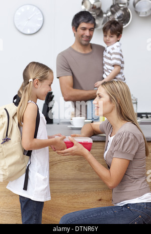Madre di dare a sua figlia il pranzo a scuola Foto Stock