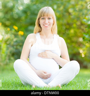 Felice donna incinta in posizione di parcheggio Foto Stock