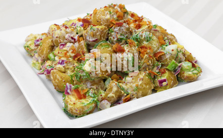 Insalata di patate servita su una piastra quadrata. Foto Stock