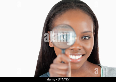 Donna sorridente con lente di ingrandimento Foto Stock