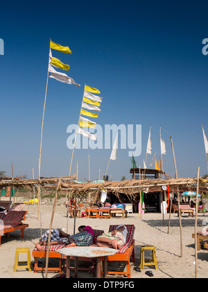 India, Goa, Morjim, i turisti a prendere il sole sui lettini Foto Stock