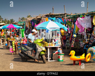 India, Goa, Morjim beach, uomo su scooter in riva al mare a souvenir shop Foto Stock